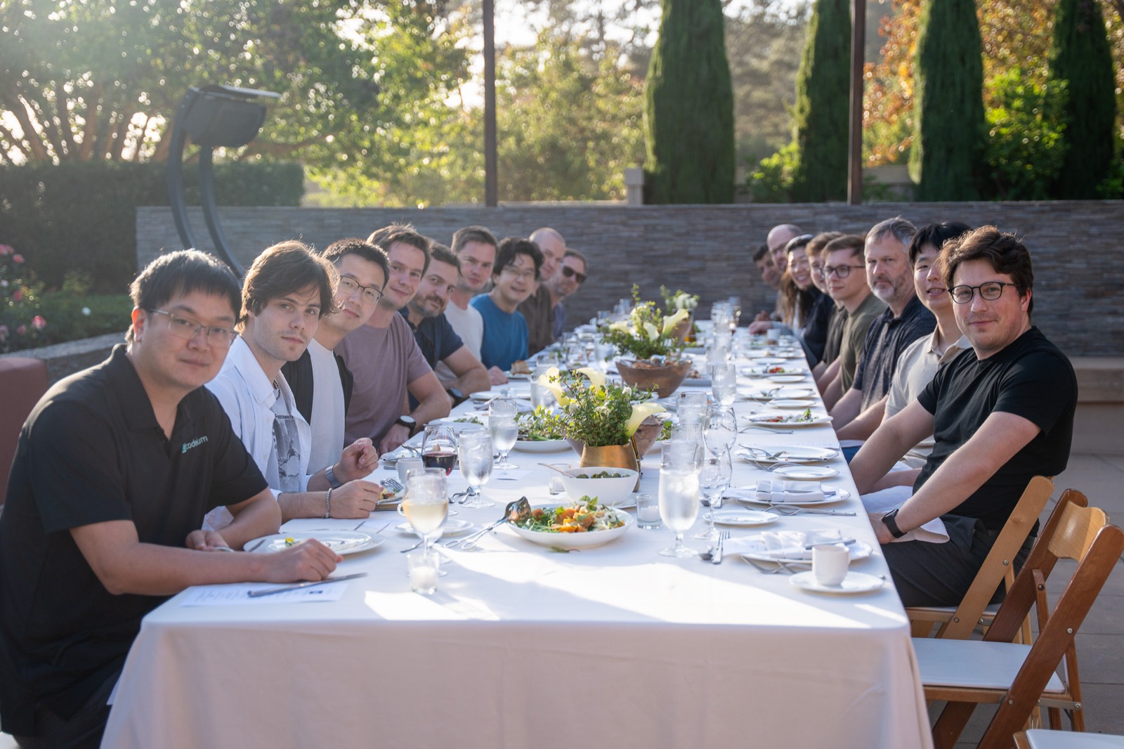 The River team gathered around a long dinner table outdoors at a company offsite