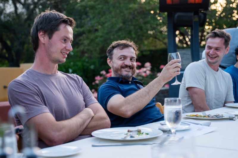 A team member raising a glass in a toast at dinner