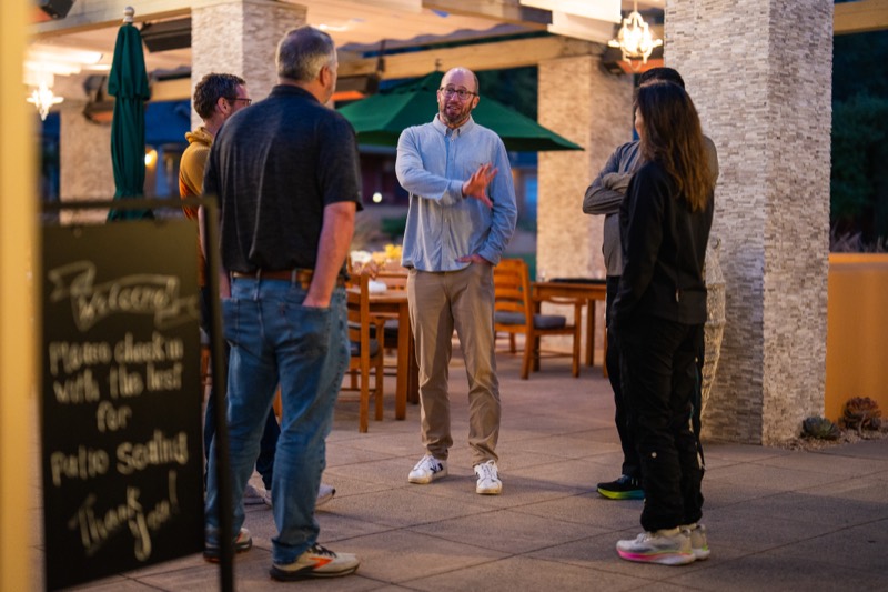 Team members chatting on a patio in the evening